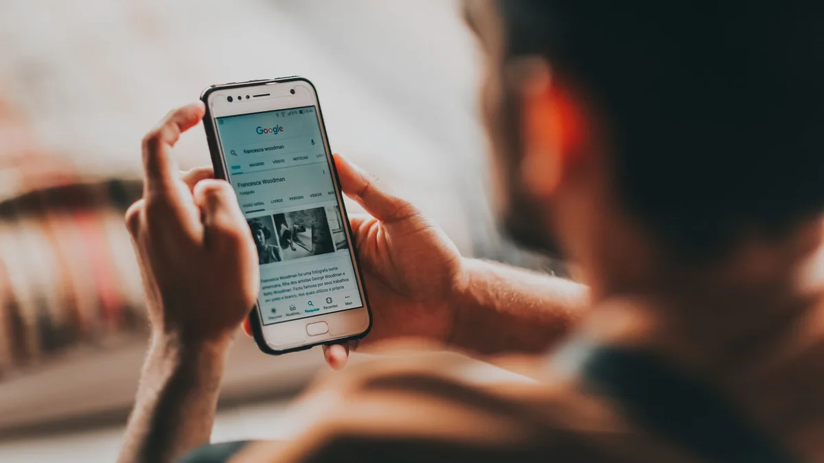 Personne consultant une recherche sur son téléphone dans la rue