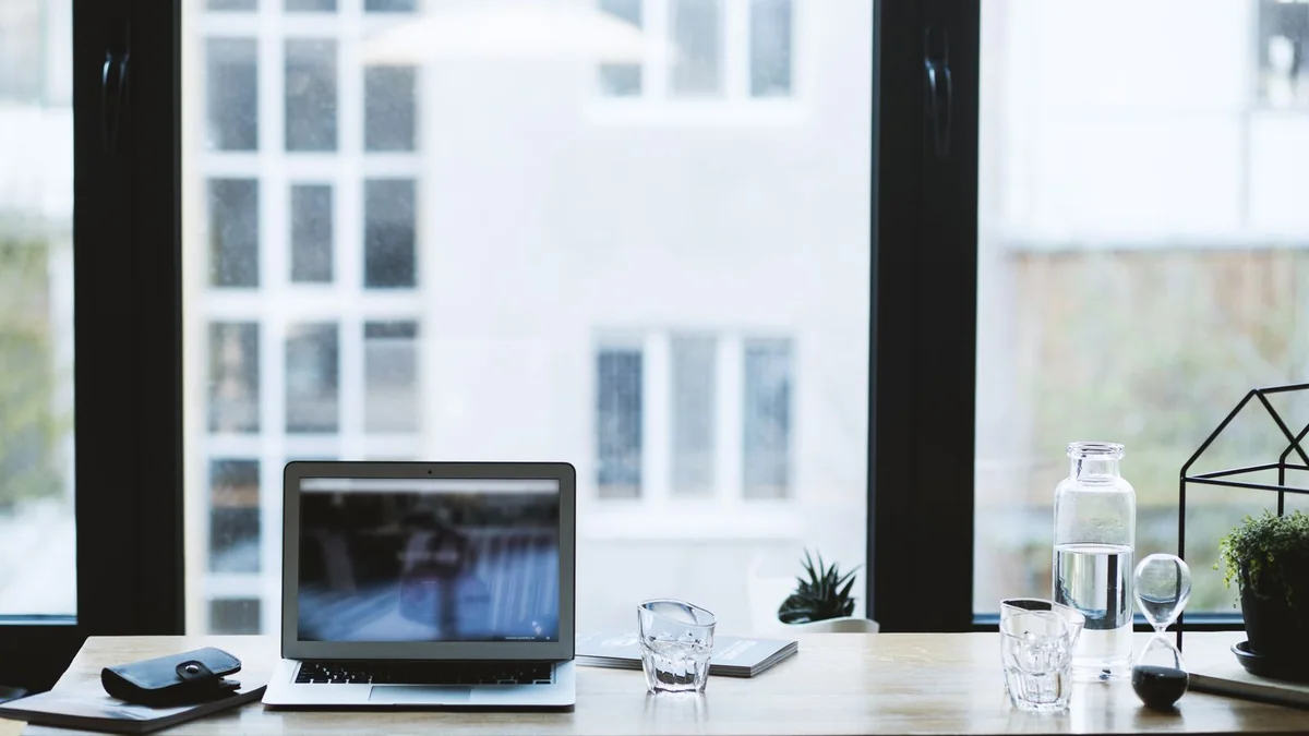 Poste de travail avec un ordinateur portable ouvert sur un bureau clair